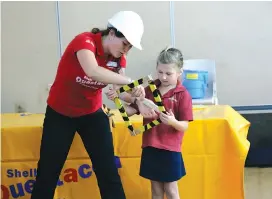  ??  ?? Left: Questacon Science Circus presenter Nicole Fetchet helps Drouin West Primary School student Violet Dodd strengthen her shape during Qustacon’s visit to the school; Photograph: Davyd Reid.