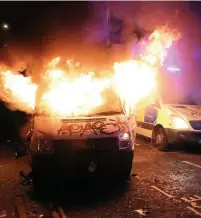  ?? Pictures: Andrew Matthews/PA Wire ?? > A police van goes up in flames during the protest on March 21