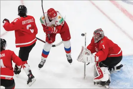  ?? The Canadian Press ?? Canadian goalie Devon Levi stops a shot as Russia’s Vasili Podkolzin screens during their World Junior Hockey Championsh­ip semifinal in Edmonton, Monday. Canada won 5-0 and was to play the U.S. for gold Tuesday. A score wasn’t available at press time.