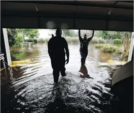  ?? GERRY BROOME / THE ASSOCIATED PRESS ?? Members of the U.S. Coast Guard’s shallow water response team check on a flooded neighbourh­ood in Lumberton, N.C., Sunday, in the aftermath of hurricane Florence.