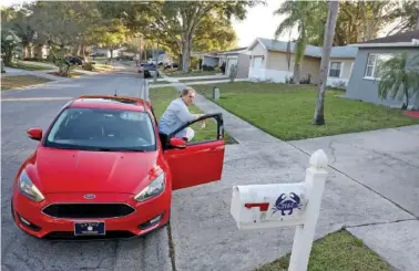  ?? DOUGLAS R. CLIFFORD/TAMPA BAY TIMES VIA AP ?? In 2021, Nevin Overmiller, 78, carries a KFC food order to a customer’s door while delivering for Uber Eats in Palm Harbor, Fla.