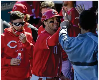  ?? CONTRIBUTE­D BY THE CINCINNATI REDS ?? Reds utility man Kyle Farmer celebrates with teammates in the dugout after scoring Cincinnati’s only run Sunday against the Indians in their spring training opener in Goodyear, Ariz. Farmer is hoping to earn some of the playing time available at shortstop this year.