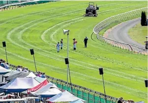  ?? RACE IMAGES SOUTH ?? Jockeys and officials examine the Riccarton track on New Zealand Cup Day on Saturday.
