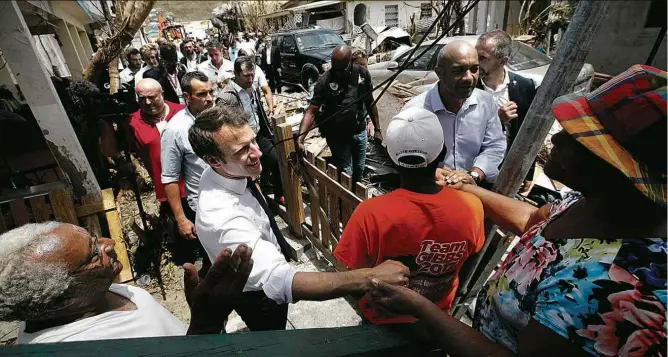  ??  ?? O presidente francês, Emmanuel Macron, cumpriment­a moradores da ilha caribenha de Saint Martin; ele visitou nesta terça (12) as regiões mais atingidas pela passagem do furacão