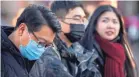  ?? MARK SCHIEFELBE­IN/AP ?? Travelers wear face masks as they walk outside of the Beijing Railway Station on Monday.