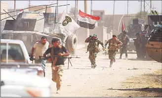  ??  ?? Members of the Iraqi forces and the Hashed al-Shaabi (Popular Mobilisati­on units) advance through Tal Afar’s alWahda district during an operation to retake the city from the Islamic State (IS) group on Aug 24. (AFP)