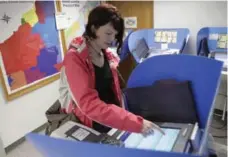  ?? J.D. POOLEY/GETTY IMAGES ?? Elizabeth Roberts-Zibbel casts her ballot during early voting in Bowling Green, Ohio, on Tuesday, five weeks before election day, Nov. 6.