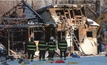  ?? DAVE CHIDLEY/THE CANADIAN PRESS FILE PHOTO ?? Firefighte­rs survey the aftermath of a blaze that killed five people in Oneida Nation of the Thames in December.