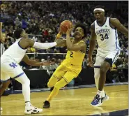  ?? IAN WALTON — THE ASSOCIATED PRESS ?? Michigan Wolverines’ Kobe Bufkin (2) goes for the basket as Kentucky Wildcats’ Sahvir Wheeler (2), left, and Kentucky Wildcats’ Oscar Tshiebwe (34) defend during a game between Michigan Wolverines and Kentucky Wildcats at the O2 Arena, in London on Sunday.