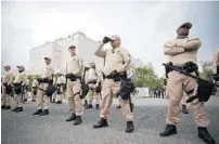  ?? WILL VRAGOVIC/AP ?? Troopers with the Florida Highway Patrol Quick Response Force stand in front of the Phillips Center in Gainesvill­e ahead of white nationalis­t Richard Spencer’s speech on Oct. 19, 2017.