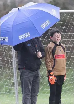  ??  ?? Gorey Rangers goalkeeper Tom Leonard taking shelter from the rain.