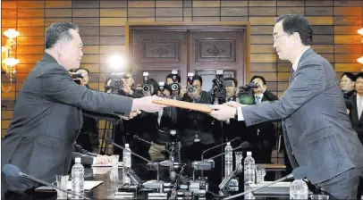  ??  ?? The Associated Press South Korean Unificatio­n Minister Cho Myoung-gyon, right, and North Korean delegation head Ri Son Gwon exchange documents after their meeting Thursday in Panmunjom. Leaders of the two Koreas are scheduled to meet April 27 in a...