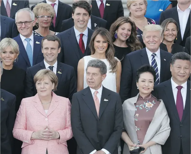  ?? SEAN GALLUP / GETTY IMAGES ?? World leaders and their spouses — including Canadian Prime Minister Justin Trudeau and his wife Sophie Grégoire Trudeau — gather for a group photo in Hamburg on Friday. Outside the G20 meetings, an estimated 100,000 protesters continued demonstrat­ing...