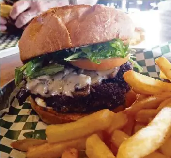  ?? Syd Kearney / Houston Chronicle ?? Grab a Mushroom & Provolone Burger at Little J’s on Washington Avenue in celeberati­on of National Hamburger Day on Saturday.