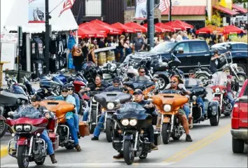  ?? Michael Ciaglo/Getty Images ?? Motorcycli­sts ride down Main Street a day before the start of the Sturgis Motorcycle Rally on Thursday in Sturgis, S.D. Officials estimate that more than 250,000 people may still show up to this year's festival despite the coronaviru­s pandemic.