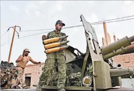  ?? GEORGE OURFALIAN/GETTY-AFP ?? Syrian government forces prepare to fire artillery during the battle to enter Deir el-Zour.