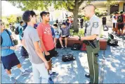  ?? PHOTOS BY GEORGE SAKKESTAD – STAFF PHOTOGRAPH­ER ?? Santa Clara County Sheriff Deputy Russell Davis visits with Saratoga High School freshman Prathik Pai, left, and Ani Balepur during lunch time.