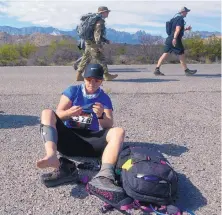  ??  ?? Janelle Bott of Thornton, Colo., changes a sock to prevent blisters during the Bataan Memorial Death March at White Sands Missile Range on Sunday.