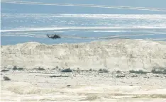  ?? (Amir Cohen/Reuters) ?? A HELICOPTER searches for the 10 teenagers who drowned on April 26 in a flash flood in Nahal Tzafit, in the Arava.