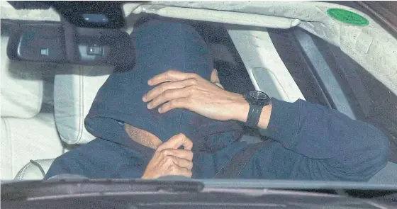  ??  ?? Jose Mourinho covers his face under a hoody as he is driven out of Chelsea’s training ground in Cobham.