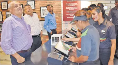  ?? Picture: ATU RASEA ?? Motibhai Group of Companies directors Jinesh Patel, left, Rajesh Patel and operations manager Mohit Narsey, look at the menu while being served at the new Burger King branch at Challenge Plaza, Laucala Beach yesterday.