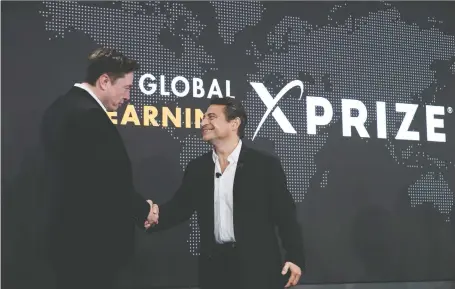  ?? MARCIO JOSE SANCHEZ/AP FILES ?? Tesla CEO Elon Musk, left, shakes hands with XPRIZE Foundation founder Peter Diamandis, last May in Los Angeles. Diamandis believes the world is entering a “new Roaring Twenties” that will result in transforma­tive goods, services, business models and behaviour.