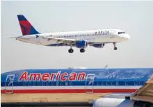  ?? ASSOCIATED PRESS FILE PHOTO ?? A Delta plane comes in for landing over an American Airlines plane at Dallas Fort Worth Internatio­nal Airport in Grapevine, Texas.