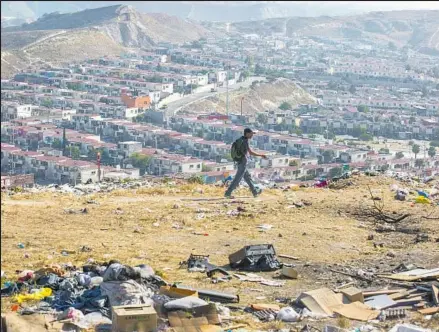  ??  ?? TRASH IS STREWN in an empty field in the hills overlookin­g an affordable housing developmen­t in Tijuana. Unlike the U.S. housing crisis and recession of a decade ago, which was also marked by regulatory failures, the Mexican housing crisis has been...