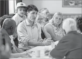  ?? ANDREW VAUGHAN/THE CANADIAN PRESS ?? Prime Minister Justin Trudeau and his four-year-old son Hadrien meet with seniors at the Milton Community Hall in North Milton on Monday.