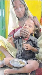  ??  ?? A Sahariya woman feeds her undernouri­shed child at an anganwadi centre in Baran district. HT FILE