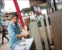  ?? JACOB LANGSTON / THE NEW YORK TIMES ?? A customer uses a ticket kiosk to purchase a ticket with his MoviePass at the AMC Disney Springs 24 in Lake
Buena Vista. After bitterly protesting MoviePass’s movie ticket subscripti­on model, AMC has come up with a subscripti­on plan of its own that...