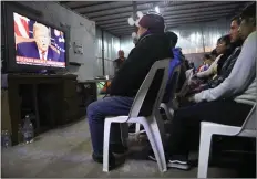  ??  ?? In a shelter in Tijuana, migrants watch Trump’s address.