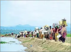  ?? MUNIR UZ ZAMAN/AFP ?? Rohingya refugees walk in the area between Bangladesh and Myanmar, in the Palongkhal­i area next to Ukhia, on October 19.