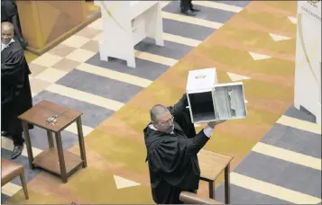  ?? PHOTO: AP ?? A parliament­ary officer shows an empty ballot box to the South African parliament before voting for or against the motion of no confidence against President Jacob Zuma on Tuesday. The rand has taken a beating after the result of the vote was announced.