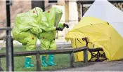  ??  ?? Police in chemical hazard suits return to the fateful bench in Salisbury, Wilts, yesterday after a protective tent that was covering the scene was partially blown away