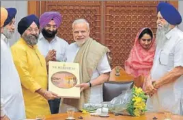  ?? HT PHOTO ?? (From left) Shiromani Akali Dal president Sukhbir Singh Badal, Delhi Sikh Gurdwara Management Committee (DSGMC) chief Manjit Singh GK and general secretary Manjinder Singh Sirsa presenting a book to Prime Minister Narendra Modi, as Union minister...