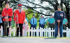  ??  ?? A child stands with Brass Wanganui players.