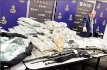  ?? Herald photo by Tijana Martin ?? Staff Sgt. Jason Walper displays some of the more than $1.2 million in drugs, firearms, and proceeds of crime seized by ALERT Lethbridge.