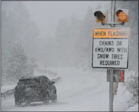  ?? JASON BEAN / RENO GAZETTE-JOURNAL FILE (2022) ?? A car passes a caution sign as heavy snow falls Dec. 1, 2022, on the Mt. Rose Highway near Reno.