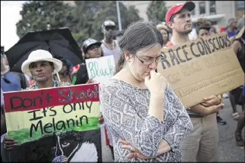  ??  ?? A protester listens during a rally before a Black Lives Matter march in Cincinnati that drew hundreds of people on July 10. Making a difference starts in people’s private lives, in their homes and conversati­ons, the writer says.