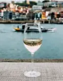  ??  ?? BELOW: A glass of white wine with Porto’s River Douro
in the background