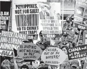  ??  ?? AKTIVIS mengadakan bantahan di hadapan pejabat konsular China, ketika Xi tiba untuk lawatan rasmi, di Manila, Filipina semalam. — Gambar AFP