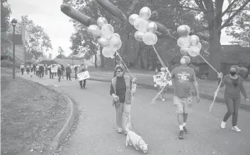  ?? MARKMIRKO/HARTFORD COURANT ?? Residents of Meadow Hill, including Carolyn Wray, Larry Abbott and Lucille DiMarco, parade past the home of John Vollinger, a WWII Marine Corps veteran, for his 100th birthday.