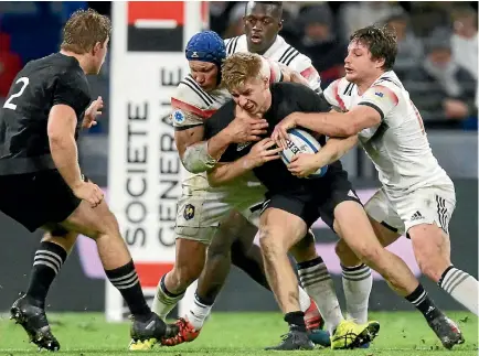  ?? PHOTO: REUTERS ?? All Blacks centre Jack Goodhue is wrapped up by several French XV tacklers during the match in Lyon yesterday.