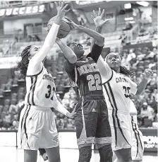  ?? STAFF PHOTO BY ROBIN RUDD ?? Mercer’s Alex Williams (22) shoots a jump shot between two UTC’s Rochelle Lee, left, and Aryanna Gilbert.