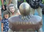  ?? PHOTOS BY DAVID KADLUBOWSK­I/AZCENTRAL SPORTS ?? TOP: Artist Jeff Carol Davenport, Art Pearce II, ASU running back Kalen Ballage, offensive lineman Sam Jones and defensive lineman Jojo Wicker unveil a statue of Pat Tillman on Wednesday. ABOVE: Tillman's mother, Mary Tillman, hugs her granddaugh­ter.