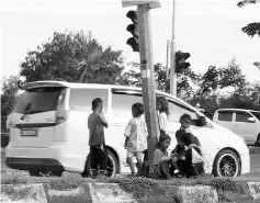  ??  ?? Palau children in Lahad Datu town waiting for vehicles to stop so they could beg for money. They could also be seen in other areas.