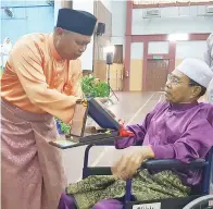  ??  ?? SAIRIN menyampaik­an Anugerah Tokoh Maulidur Rasul peringkat daerah Keningau kepada Muchtar.