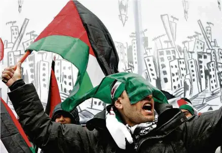  ?? François Lenoir/Reuters ?? Manifestan­te ergue bandeira da Palestina em protesto contra visita de Netanyahu em Bruxelas na segunda-feira (11) ELEIÇÃO