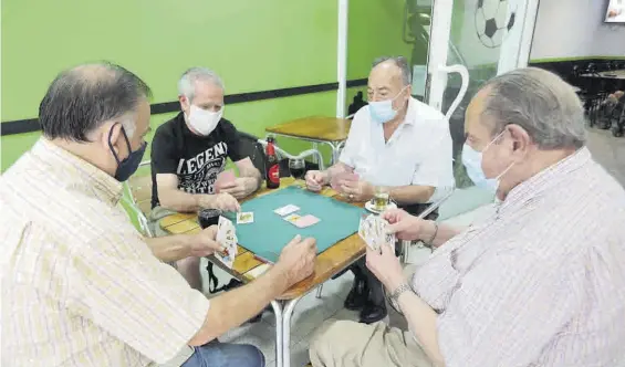  ??  ?? Un grupo de mayores juegan a las cartas en un bar el pasado mes de junio.